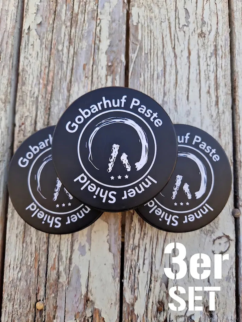 Drei schwarze Tiegel der Gobarhuf Paste Inner Shield Hufpaste als praktisches 3er-Set für die Hufpflege auf einem rustikalen Holzuntergrund.